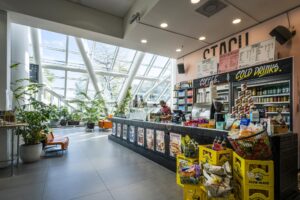 Moderne koffiebar STACH aan de Johan Huizingalaan met veel daglicht, planten en een breed assortiment aan snacks en drankjes.